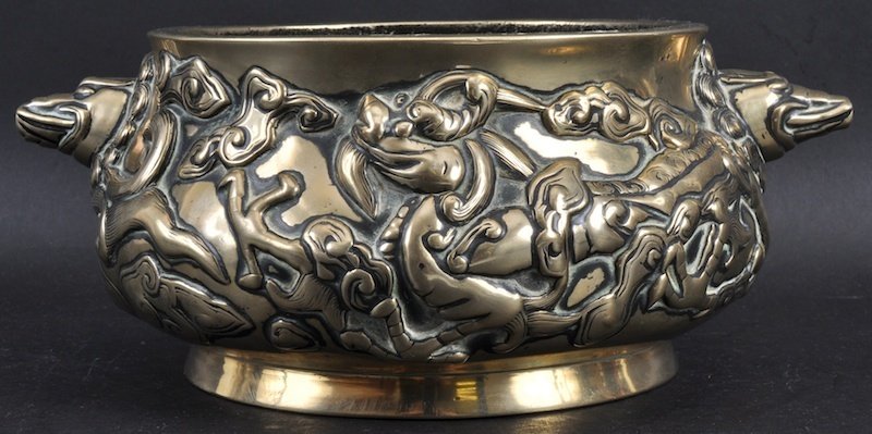 A 19TH CENTURY CHINESE TWIN HANDLED BRONZE CENSER: A 19TH CENTURY CHINESE TWIN HANDLED BRONZE CENSER bearing Xuande marks to base, decorated in relief with dragons. Minor wear. 10.25ins wide.