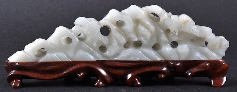 A GOOD 19TH CENTURY CHINESE CARVED WHITE JADE PIERCED: A GOOD 19TH CENTURY CHINESE CARVED WHITE JADE PIERCED ROCK depicting a doe and stag roaming within emerging fungus. 6.5ins wide.