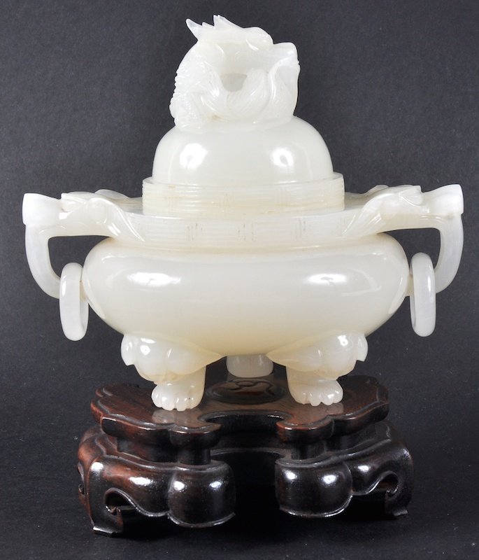 AN EARLY 20TH CENTURY CHINESE CARVED WHITE JADE AND: AN EARLY 20TH CENTURY CHINESE CARVED WHITE JADE AND COVER flanked by two mask heads. 5ins high.