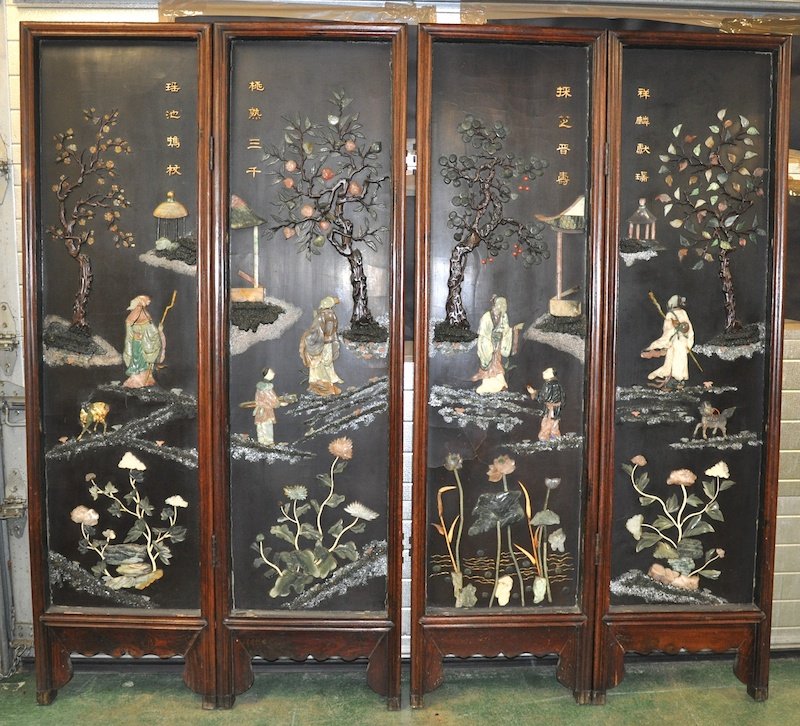 A LATE 19TH CENTURY CHINESE CARVED HARDWOOD FOLDING: A LATE 19TH CENTURY CHINESE CARVED HARDWOOD FOLDING SCREEN inlaid in various hardstones including agate, jade and soapstone depicting figures within interiors. 7ft 1ins x 6ft 6ins.