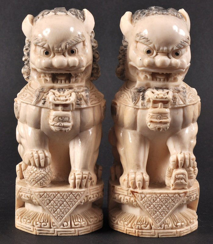 A PAIR OF EARLY 20TH CENTURY CHINESE IVORY DOGS OF FOE: A PAIR OF EARLY 20TH CENTURY CHINESE IVORY DOGS OF FOE bearing Qianlong marks to base, upon well carved bases. Good condition. 5.25ins high.