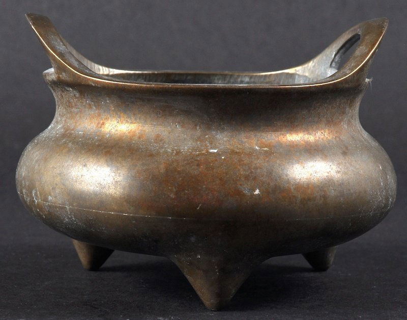 A 19TH CENTURY CHINESE TWIN HANDLED BRONZE CENSER: A 19TH CENTURY CHINESE TWIN HANDLED BRONZE CENSER bearing Xuande marks to base, upon tripod feet. Minor wear. 4.25ins wide.