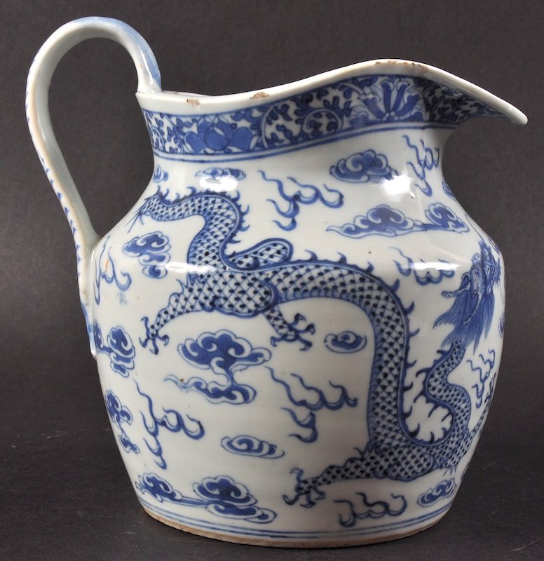 A 19TH CENTURY CHINESE BLUE AND WHITE PORCELAIN JUG: A 19TH CENTURY CHINESE BLUE AND WHITE PORCELAIN JUG painted with four claw dragons pursuing a flaming pearl. Minor fritting. 7.5ins high.