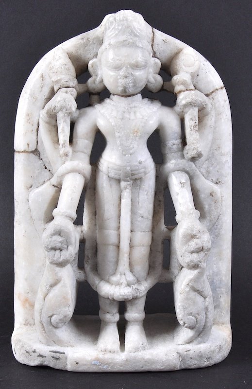 AN EARLY INDIAN CARVED WHITE MARBLE FIGURE OF A DEITY: AN EARLY INDIAN CARVED WHITE MARBLE FIGURE OF A DEITY modelled standing by an arch. Few repairs. 10ins high.