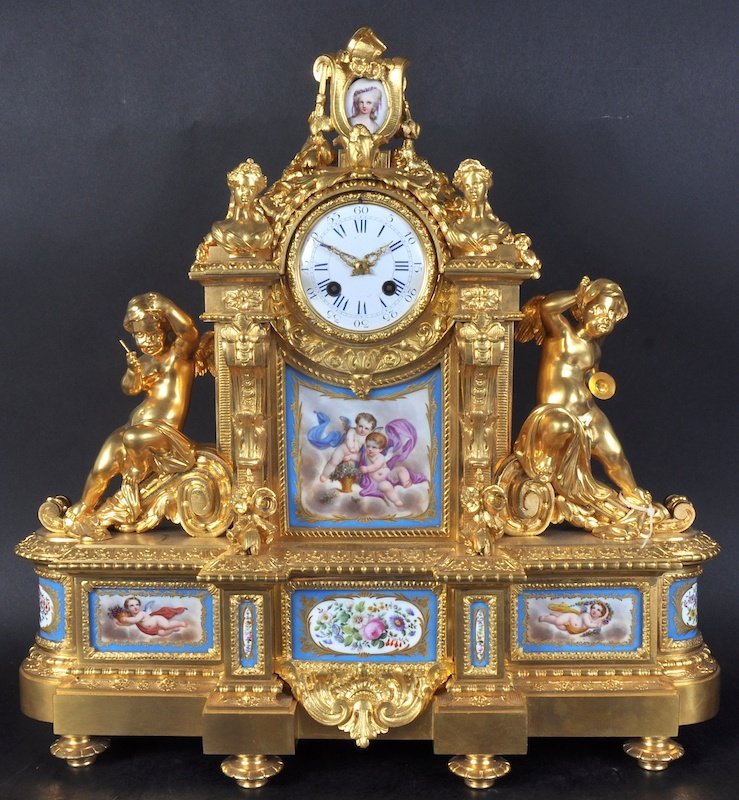 A VERY GOOD 19TH CENTURY FRENCH ORMOLU CLOCK, with: A VERY GOOD 19TH CENTURY FRENCH ORMOLU CLOCK, with Sevres porcelain panels, the case with bust of ladies and cupid mounts. 20 inches high, 20 inches wide.