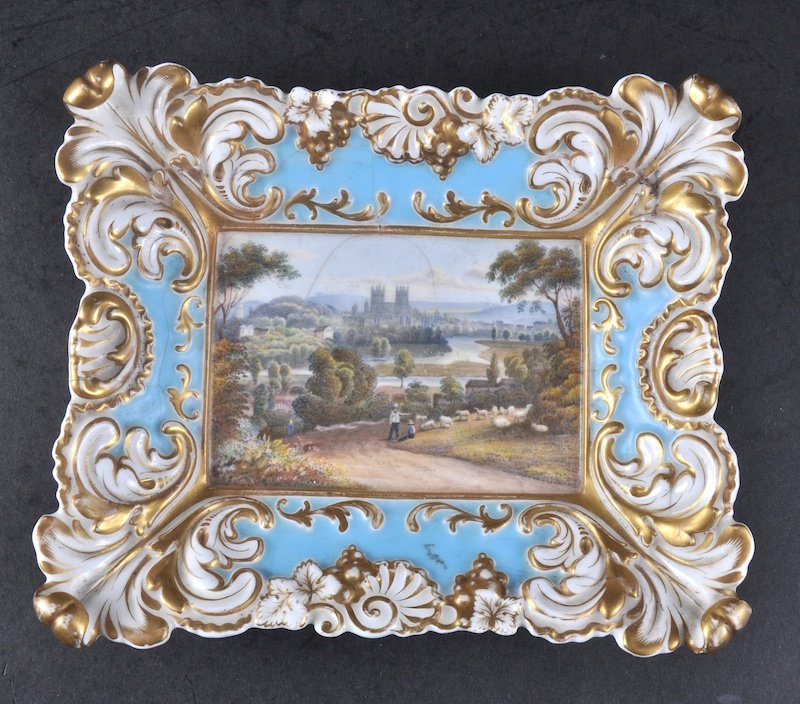 A CHAMBERLAIN WORCESTER PLAQUE with integral frame: A CHAMBERLAIN WORCESTER PLAQUE with integral frame painted with a view of Exeter (stress cracks).