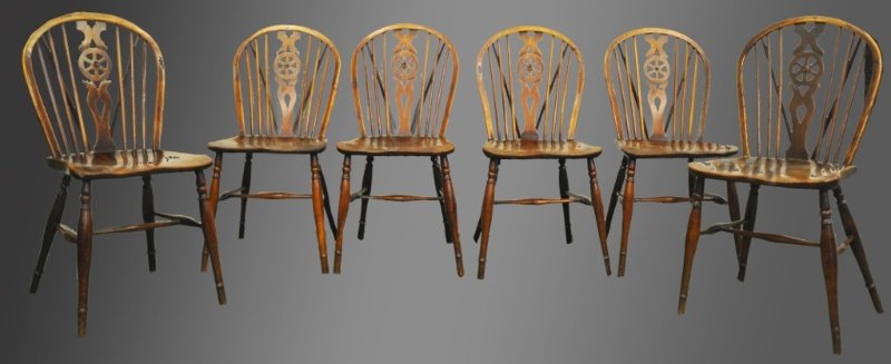 A GOOD SET OF SIX EARLY 19TH CENTURY ELM WHEEL BACK: A GOOD SET OF SIX EARLY 19TH CENTURY ELM WHEEL BACK DINING CHAIRS, arched front spindle supports, carved saddle seats on turned legs with stretcher. Provenance: John Keil, Bath 1985.