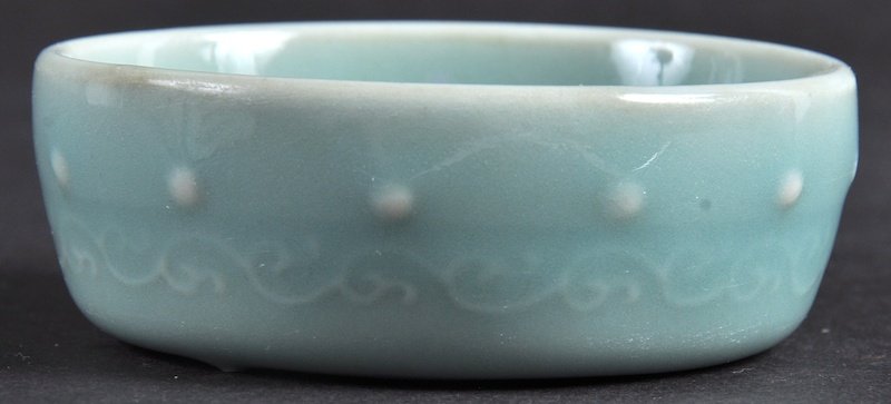 AN EARLY 20TH CENTURY CHINESE GREEN CELADON BRUSH: AN EARLY 20TH CENTURY CHINESE GREEN CELADON BRUSH WASHER bearing Qianlong marks to base, decorated with motifs. Good condition. 3ins diameter.