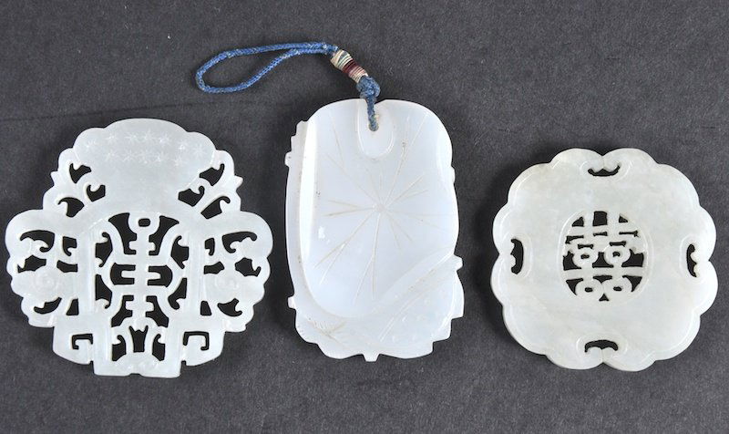 AN EARLY 20TH CENTURY CHINESE CARVED WHITE JADE FOLIATE: AN EARLY 20TH CENTURY CHINESE CARVED WHITE JADE FOLIATE PENDANT together with two hardstone plaques. Good condition. (3)