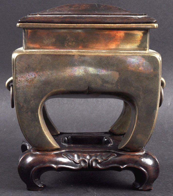 AN UNUSUAL CHINESE QING DYNASTY BRONZE CENSER with: AN UNUSUAL CHINESE QING DYNASTY BRONZE CENSER with hardwood cover and base, of square form upon splayed legs. Minor wear. 5ins wide.