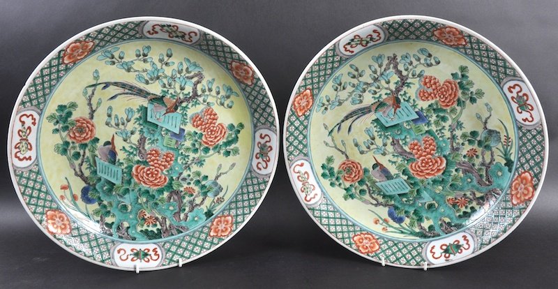 A PAIR OF LATE 19TH CENTURY CHINESE FAMILLE VERTE: A PAIR OF LATE 19TH CENTURY CHINESE FAMILLE VERTE CIRCULAR CHARGERS bearing Kangxi marks to base, painted with birds upon flowering rock. Small rim chip to one. 15.75ins diameter.