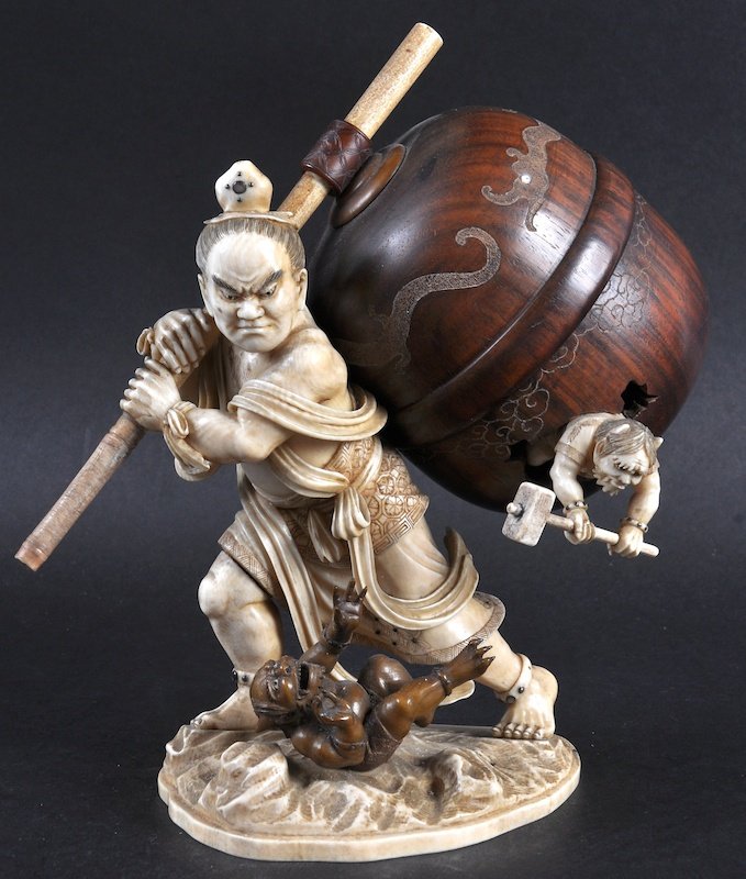 A SUPERB 19TH CENTURY JAPANESE MEIJI PERIOD IVORY: A SUPERB 19TH CENTURY JAPANESE MEIJI PERIOD IVORY FIGURE OF A MALE modelled holding a carved wood barrel upon his back with flailing oni, upon a naturalistic base. Signed. 7.5ins high.