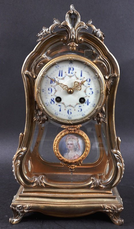 A 19TH CENTURY FRENCH ORMOLU MANTLE CLOCK with glass: A 19TH CENTURY FRENCH ORMOLU MANTLE CLOCK with glass front and sides, the movement by G. & B., cream face, blue numbers and painted with garlands, the pendulum painted with a portrait of a pretty lady