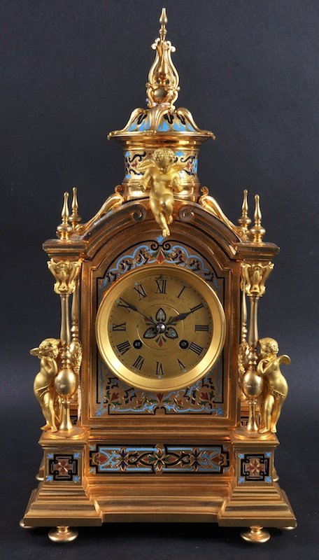 A VERY GOOD 19TH CENTURY FRENCH ORMOLU AND CHAMPLEVE: A VERY GOOD 19TH CENTURY FRENCH ORMOLU AND CHAMPLEVE ENAMEL CLOCK, the movement stamped G.V. 31483, Retailed by EDWARD & SONS, GLASGOW, with column sides and mounted with three cupids. 16ins high.