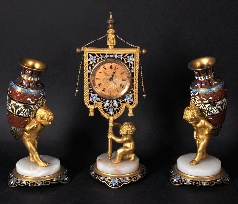 A SUPERB SMALL 19TH CENTURY FRENCH THREE PIECE CLOCK: A SUPERB SMALL 19TH CENTURY FRENCH THREE PIECE CLOCK GARNITURE, stamped HENRY, the clock formed as a cupid holding a banner in which is the clock, complete with a pair of side urns, cupids holding a v