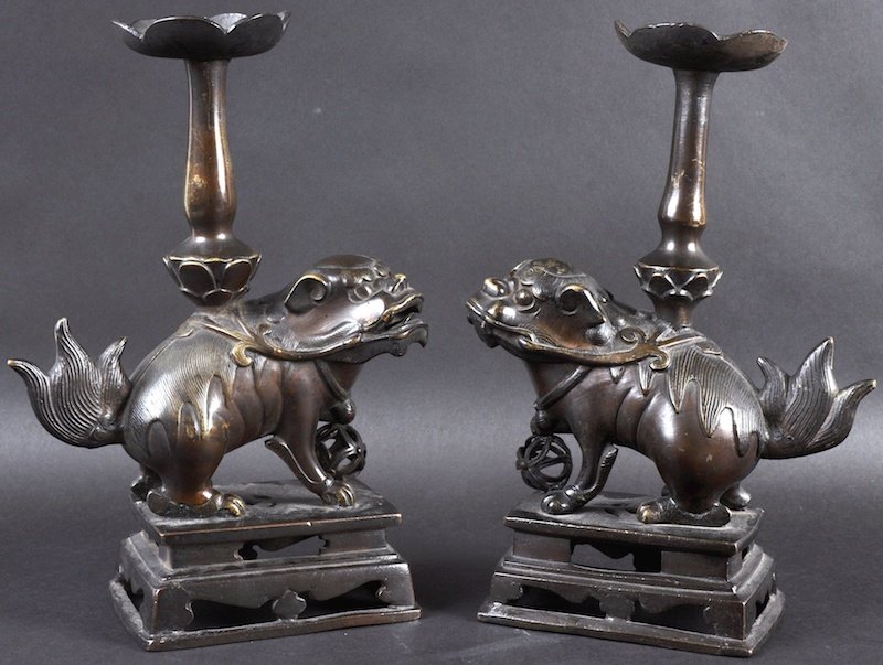 A PAIR OF 18TH CENTURY CHINESE DOGS OF FOE Late: A PAIR OF 18TH CENTURY CHINESE DOGS OF FOE Late Qianlong, modelled with lotus shaped pricket candlesticks upon their backs, supported upon square plinths. 12ins high.