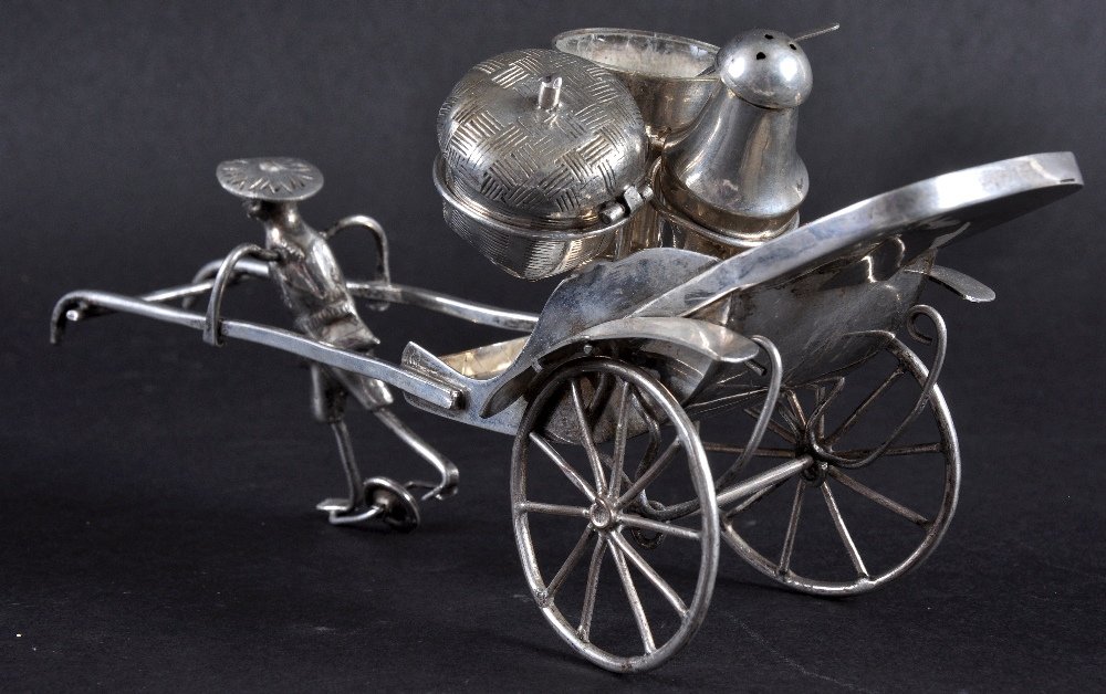 AN EARLY 20TH CENTURY CHINESE WHITE METAL CRUET in the: AN EARLY 20TH CENTURY CHINESE WHITE METAL CRUET in the form of a male holding a rickshaw. 7.75ins wide.