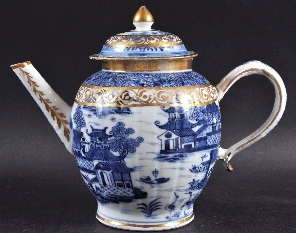 AN 18TH CENTURY CHINESE EXPORT BLUE AND WHITE TEAPOT: AN 18TH CENTURY CHINESE EXPORT BLUE AND WHITE TEAPOT AND COVER painted with landscapes, overlaid in gilt. 7.5ins high.