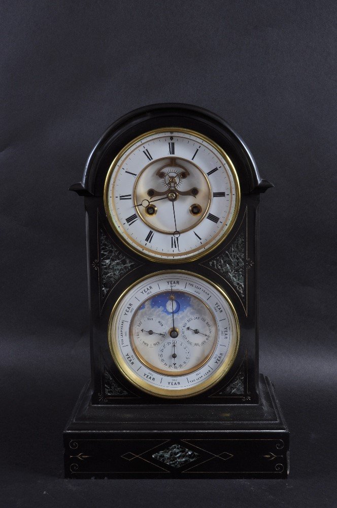 A GOOD VICTORIAN BLACK MARBLE CLOCK with two large: A GOOD VICTORIAN BLACK MARBLE CLOCK with two large dials, eight day movement with black and white Roman numerals over a dial with year, day, month and 1-31, both 5.5ins diameter. 16ins high. £700-800