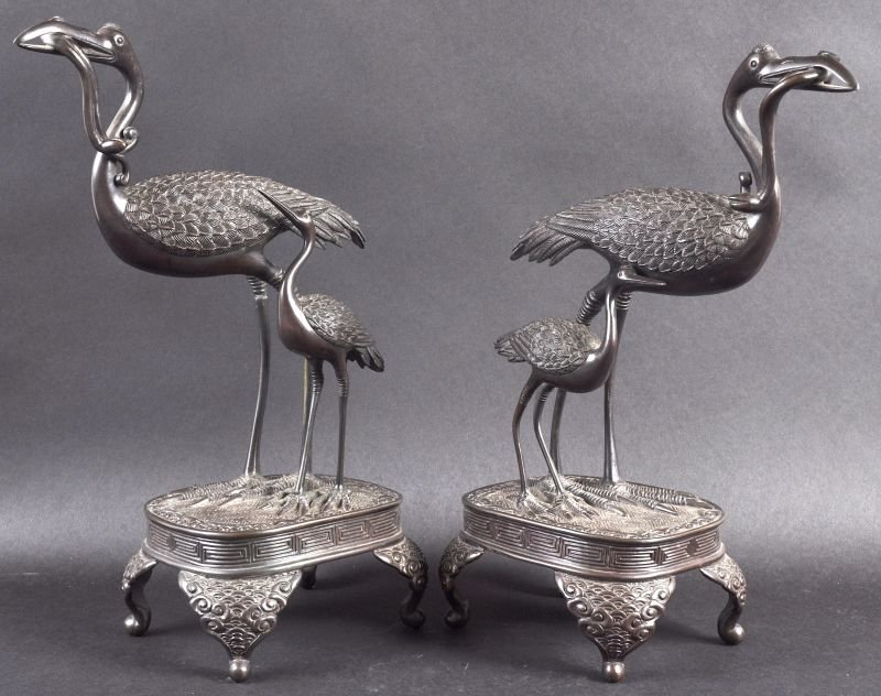 A PAIR OF LATE 19TH CENTURY JAPANESE MEIJI PERIOD: A PAIR OF LATE 19TH CENTURY JAPANESE MEIJI PERIOD BRONZE FIGURES OF CRANES modelled upon square bases. 14ins high.