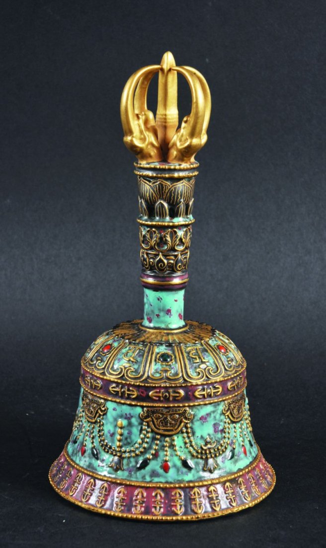 AN UNUSUAL CHINESE PORCELAIN BELL, in imitation of a: AN UNUSUAL CHINESE PORCELAIN BELL, in imitation of a Tibetan bronze original, the bell with multiple relief border decoration, 8in high.