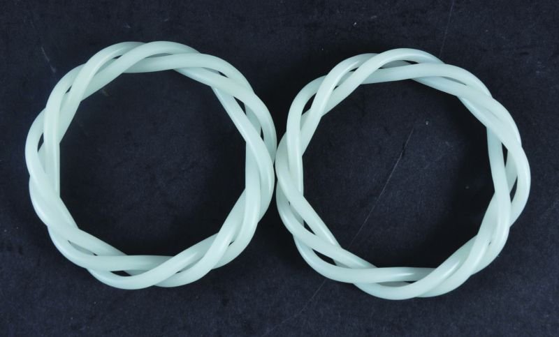 A PAIR OF CHINESE THREE-STRAND WHITE JADE BANGLES,: A PAIR OF CHINESE THREE-STRAND WHITE JADE BANGLES, 3.1in diameter.