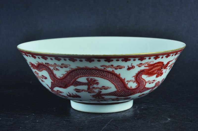 A CHINESE ROUGE-DE-FER PORCELAIN DRAGON BOWL, the: A CHINESE ROUGE-DE-FER PORCELAIN DRAGON BOWL, the rounded exterior sides painted with two dragons disputing a flaming pearl, the base with a Qianlong seal mark, 6.4in diameter.