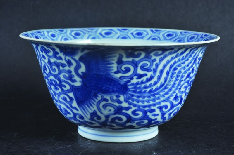 A CHINESE KANGXI PERIOD BLUE & WHITE PORCELAIN PHOENIX: A CHINESE KANGXI PERIOD BLUE & WHITE PORCELAIN PHOENIX BOWL, circa 1700, the sides painted with repeated phoenix reserved on a formal scroll ground, the base with a six-character Chenghua mark, 6.1in 