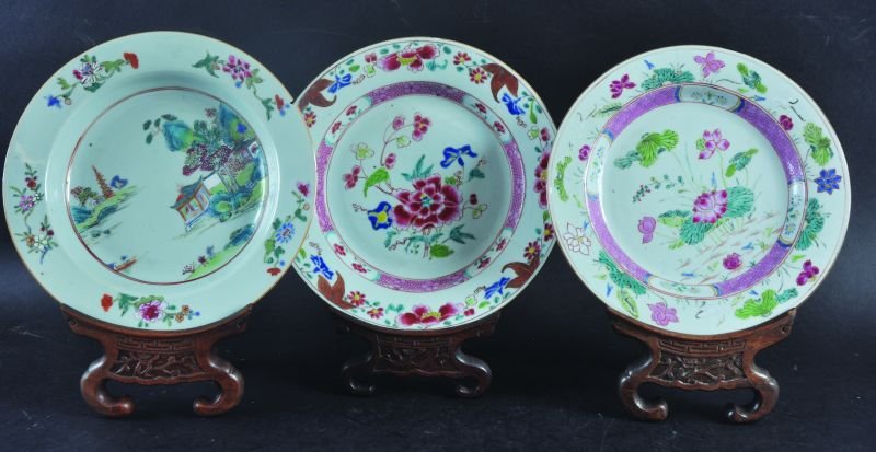 THREE 18TH CENTURY CHINESE QIANLONG PERIOD FAMILLE ROSE: THREE 18TH CENTURY CHINESE QIANLONG PERIOD FAMILLE ROSE PORCELAIN PLATES, together with three carved wood plate stands, the largest plate 9.1in diameter, the stands 8.2in high. (6)