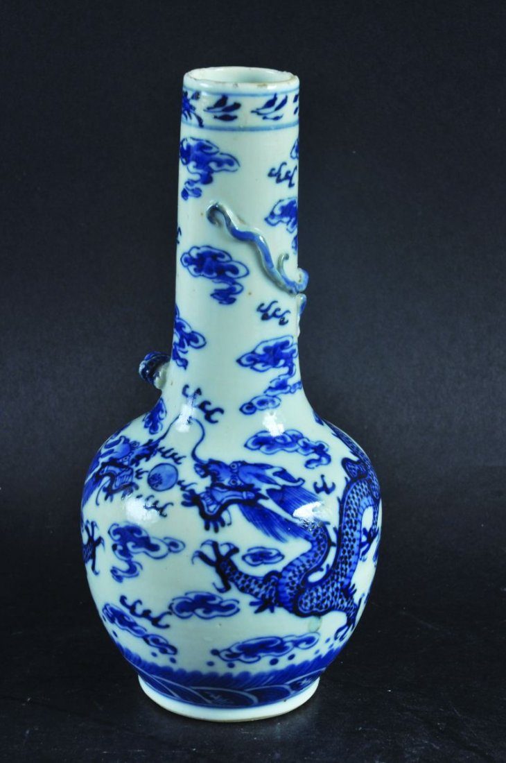 A 19TH CENTURY CHINESE BLUE & WHITE DRAGON PORCELAIN: A 19TH CENTURY CHINESE BLUE & WHITE DRAGON PORCELAIN BOTTLE VASE, the sides painted with dragons disputing a flaming pearl amidst cloud scrolls, the tapering neck moulded with a sinuous chilong, the b