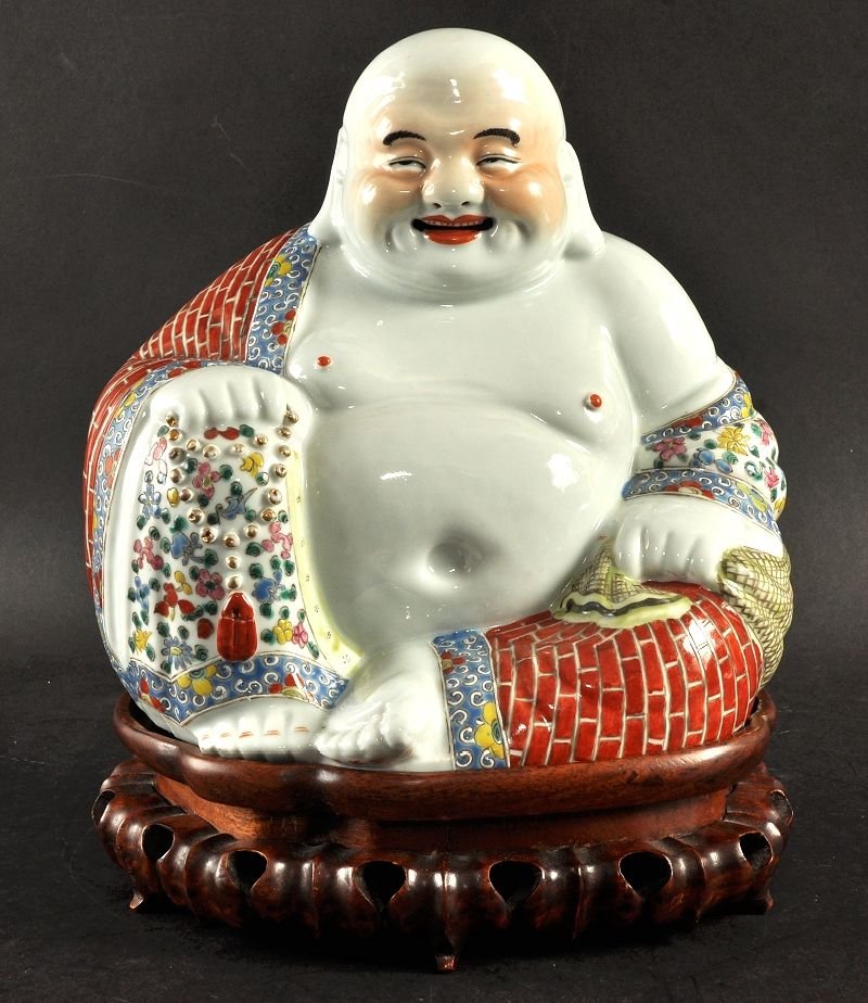 A GOOD EARLY 20TH CENTURY CHINESE FAMILLE ROSE: A GOOD EARLY 20TH CENTURY CHINESE FAMILLE ROSE PORCELAIN MODEL OF BUDAI, together with a fitted hard wood stand, the unglazed base with an impressed oval seal mark, the buddha 10in wide & also 10in hi