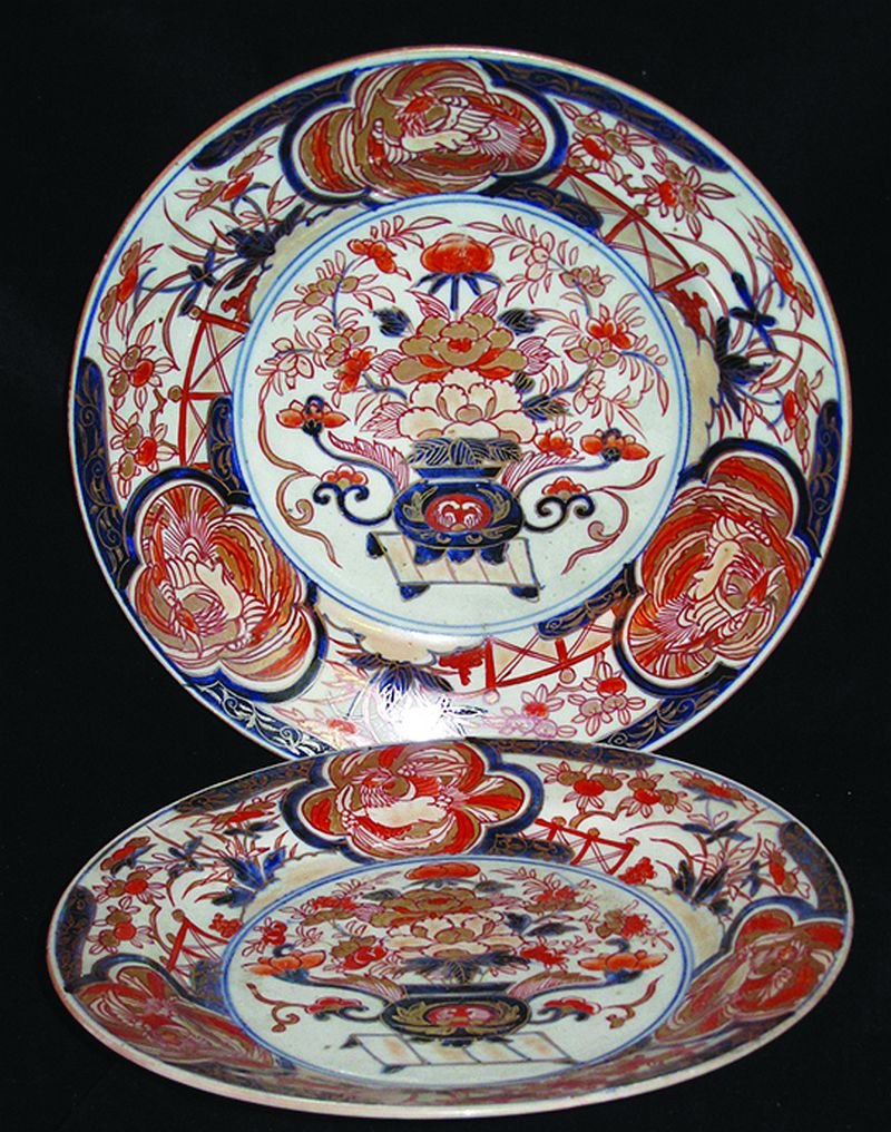 AN EARLY JAPANESE IMARI DISH, circa 1700, painted to: AN EARLY JAPANESE IMARI DISH, circa 1700, painted to its centre with a jardinière of flowers, the rim with phoenix panels, the base with spur marks, 10.6in diameter; together with a smaller similar e