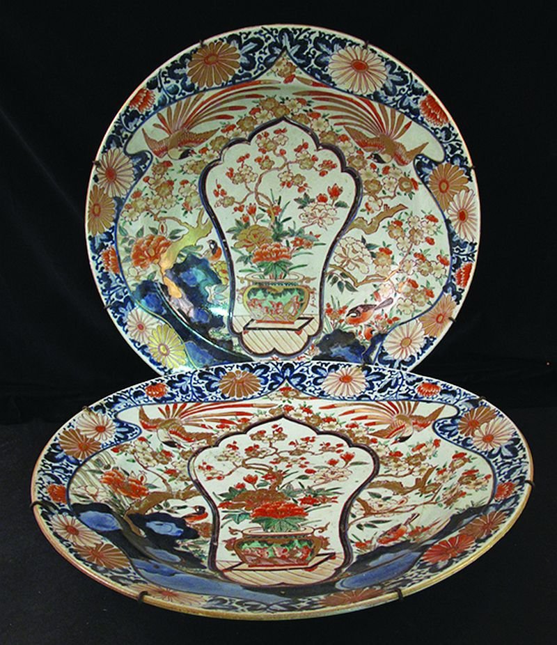 A VERY LARGE PAIR OF EARLY JAPANESE IMARI EDO PERIOD: A VERY LARGE PAIR OF EARLY JAPANESE IMARI EDO PERIOD PORCELAIN CHARGERS, circa 1700, each painted to its centre with a shaped panel of a jardinière of flowers, the panel enclosed by a garden scene of