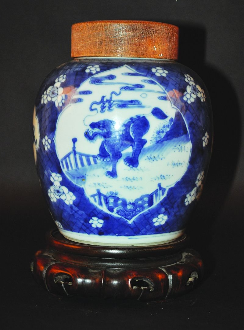 A GOOD CHINESE KANGXI PERIOD BLUE & WHITE PORCELAIN: A GOOD CHINESE KANGXI PERIOD BLUE & WHITE PORCELAIN JAR, circa 1700, together with a carved hardwood stand and a wood cover, the jar painted to its sides with quatrefoil panels of kylin, precious obje