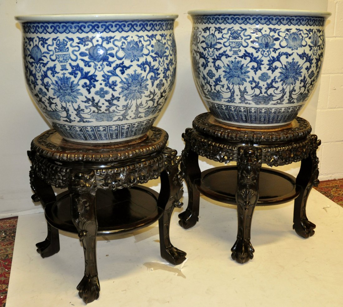 A LARGE PAIR OF CHINESE BLUE & WHITE JARDINIERES: A LARGE PAIR OF CHINESE BLUE & WHITE PORCELAIN JARDINIÈRES, possibly 18th/19th Century, together with a pair of fine quality 19th Century Chinese carved hardwood vase stands with marble insets, the j