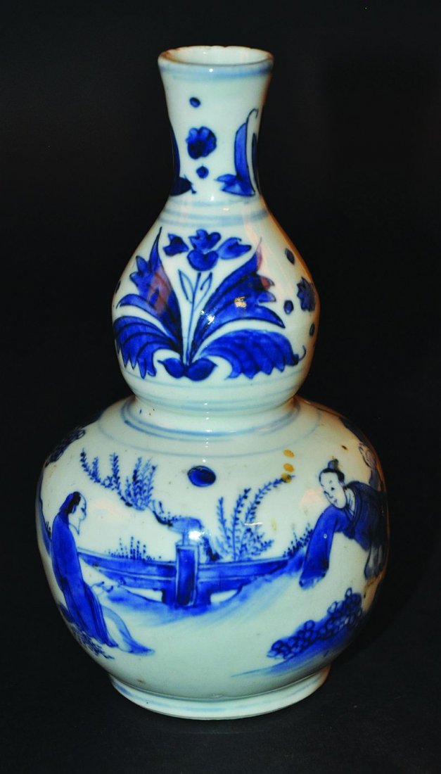 A GOOD 17TH CENTURY CHINESE TRANSITIONAL PERIOD BLUE &: A GOOD 17TH CENTURY CHINESE TRANSITIONAL PERIOD BLUE & WHITE DOUBLE-GOURD PORCELAIN VASE, the body painted with two figures conversing in a garden setting beneath stylised tulips to the neck, 7.1in hi
