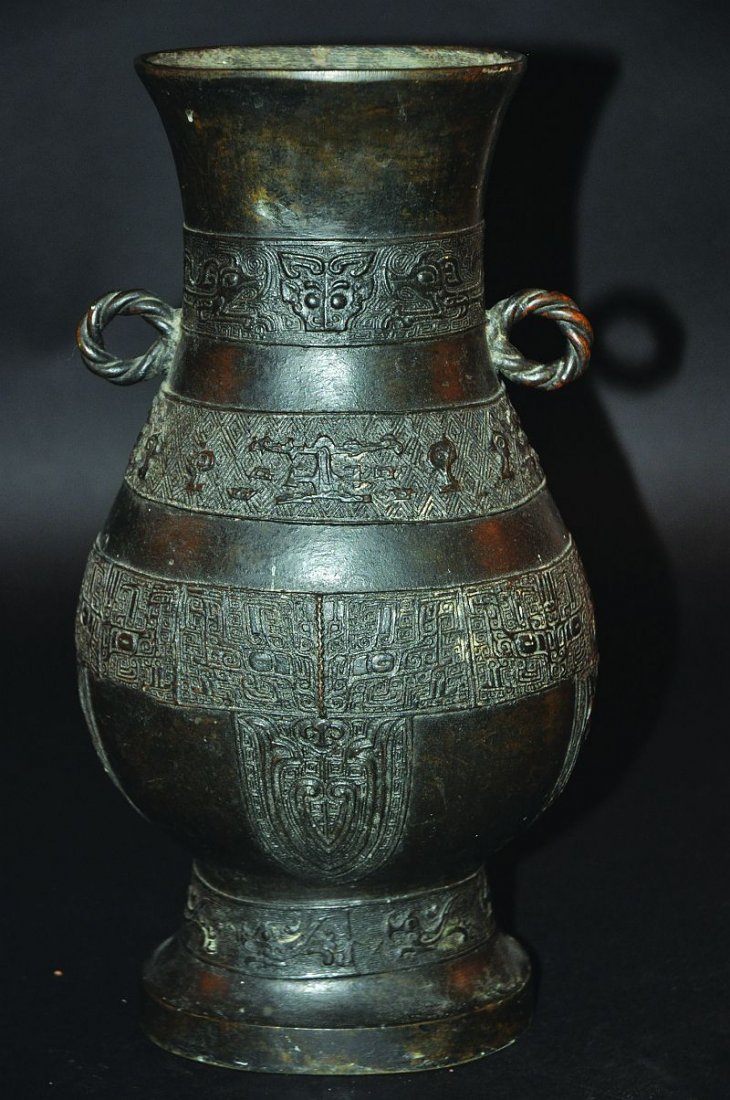 A 19TH/20TH CENTURY CHINESE MING-STYLE BRONZE HU VASE,: A 19TH/20TH CENTURY CHINESE MING-STYLE BRONZE HU VASE, the sides with bands of archaic decoration, the neck with double rope ring handles, 12.9in high. £80-120