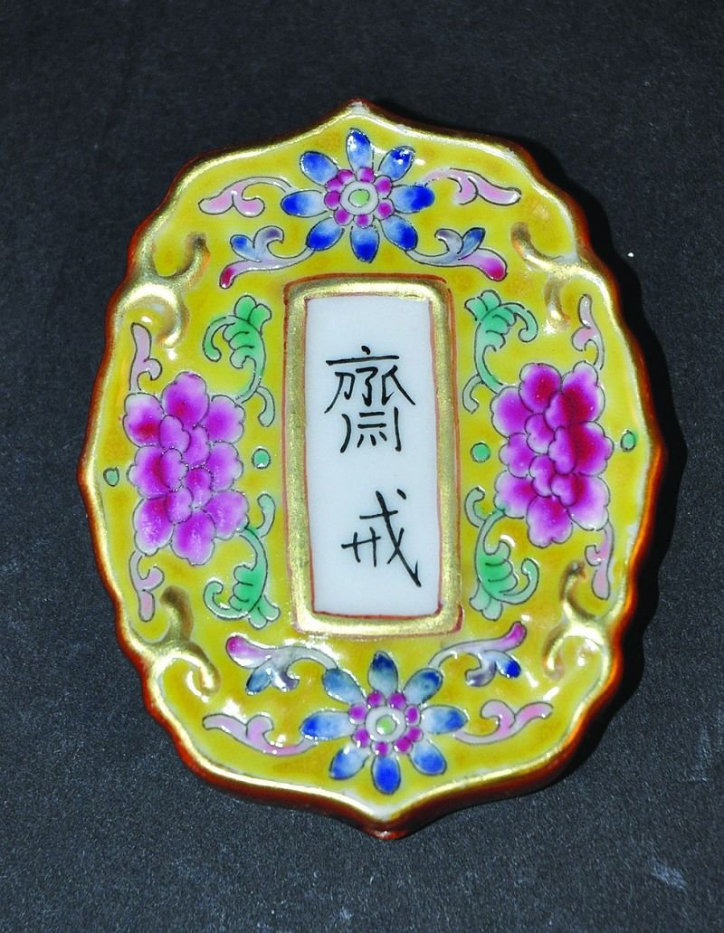 A SMALL CHINESE FAMILLE ROSE PORCELAIN TABLET, of: A SMALL CHINESE FAMILLE ROSE PORCELAIN TABLET, of shaped quatrefoil form, each side centred by a panel of calligraphy enclosed by scroll-stemmed foliage reserved on a yellow ground, 2.5in x 2in at wid