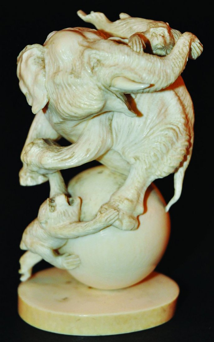 A SIGNED LATE 19TH CENTURY JAPANESE MEIJI PERIOD IVORY: A SIGNED LATE 19TH CENTURY JAPANESE MEIJI PERIOD IVORY OKIMONO, of an elephant fighting two monkeys whilst balanced on a spherical ball, the base with a stained and engraved signature in a rectangular