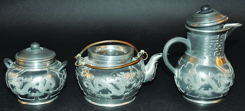 AN EARLY 20TH CENTURY CHINESE PEWTER CASED GREY YIXING: AN EARLY 20TH CENTURY CHINESE PEWTER CASED GREY YIXING TEAPOT & COVER, the sides with dragon decoration and a Shou symbol, the base with an impressed mark, 7in long & 3.7in high; together with a sugar