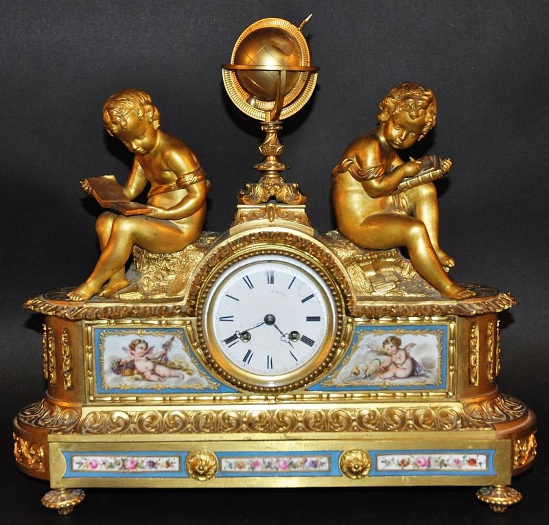 A GOOD 19TH CENTURY FRENCH ORMOLU MANTLE CLOCK with: A GOOD 19TH CENTURY FRENCH ORMOLU MANTLE CLOCK with painted SEVRES panels, the eight day movement in a good quality case with terrestrial globe and two cupids, the Sevres panels painted with cupids an