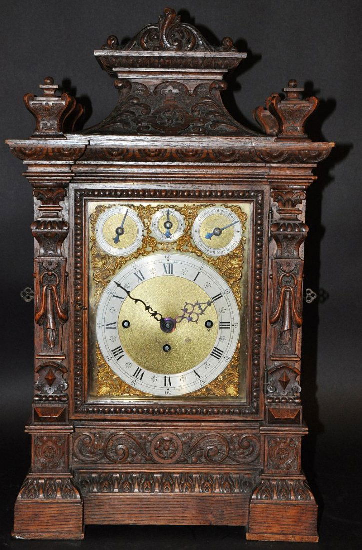 A GOOD CARVED OAK VICTORIAN BRACKET CLOCK, made in: A GOOD CARVED OAK VICTORIAN BRACKET CLOCK, made in Germany, chiming on eight bells, chime on four gongs with chime and silent eight day movement, with silvered dial. 24ins high. £1500-2000.