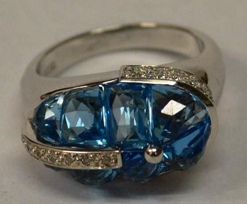 AN 18CT WHITE GOLD AQUAMARINE AND DIAMOND DRESS RING: AN 18CT WHITE GOLD AQUAMARINE AND DIAMOND DRESS RING set with eight aquamarines and small diamond. £300-500.