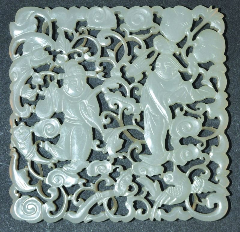 A GOOD CHINESE PIERCED AND CARVED WHITE JADE PLAQUE,: A GOOD CHINESE PIERCED AND CARVED WHITE JADE PLAQUE, depicting two Immortals amidst lingzhi and cloud scrolls, 2.9in square. £300-400