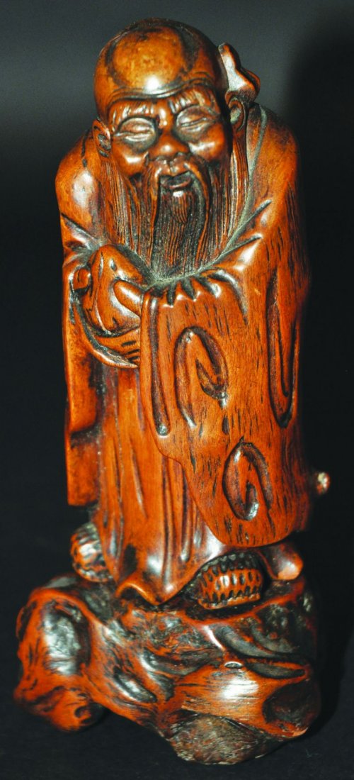 A 19TH CENTURY CHINESE SECTIONAL ROOTWOOD CARVING OF: A 19TH CENTURY CHINESE SECTIONAL ROOTWOOD CARVING OF SHOU SHING, bearing a peach and standing on a rocky plinth, 6.4in high. £200-300