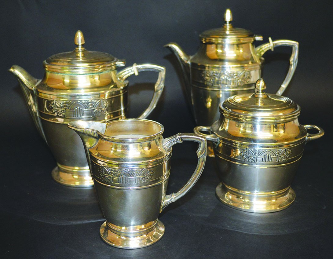 AN ART DECO DESIGN FOUR PIECE TEA SET with an Art Deco: AN ART DECO DESIGN FOUR PIECE TEA SET with an Art Deco band comprising teapot, hot water jug, sugar basin and milk jug. £50-80.