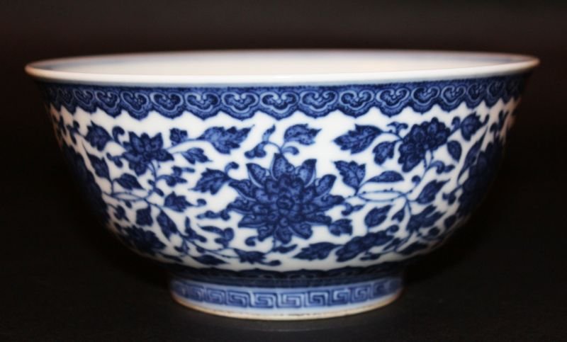 A CHINESE MING-STYLE BLUE & WHITE PORCELAIN BOWL, the: A CHINESE MING-STYLE BLUE & WHITE PORCELAIN BOWL, the exterior sides decorated with a formal band of scrolling leaf-stemmed flowerheads, between formal borders, 6.8in diameter & 3.2in high. £300-400.