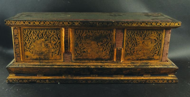 A SOUTH-EAST ASIAN GILT WOOD PLINTH, decorated with: A SOUTH-EAST ASIAN GILT WOOD PLINTH, decorated with scenes of fighting Gods between floral borders, 33in x 10.75in x 12.5in high.