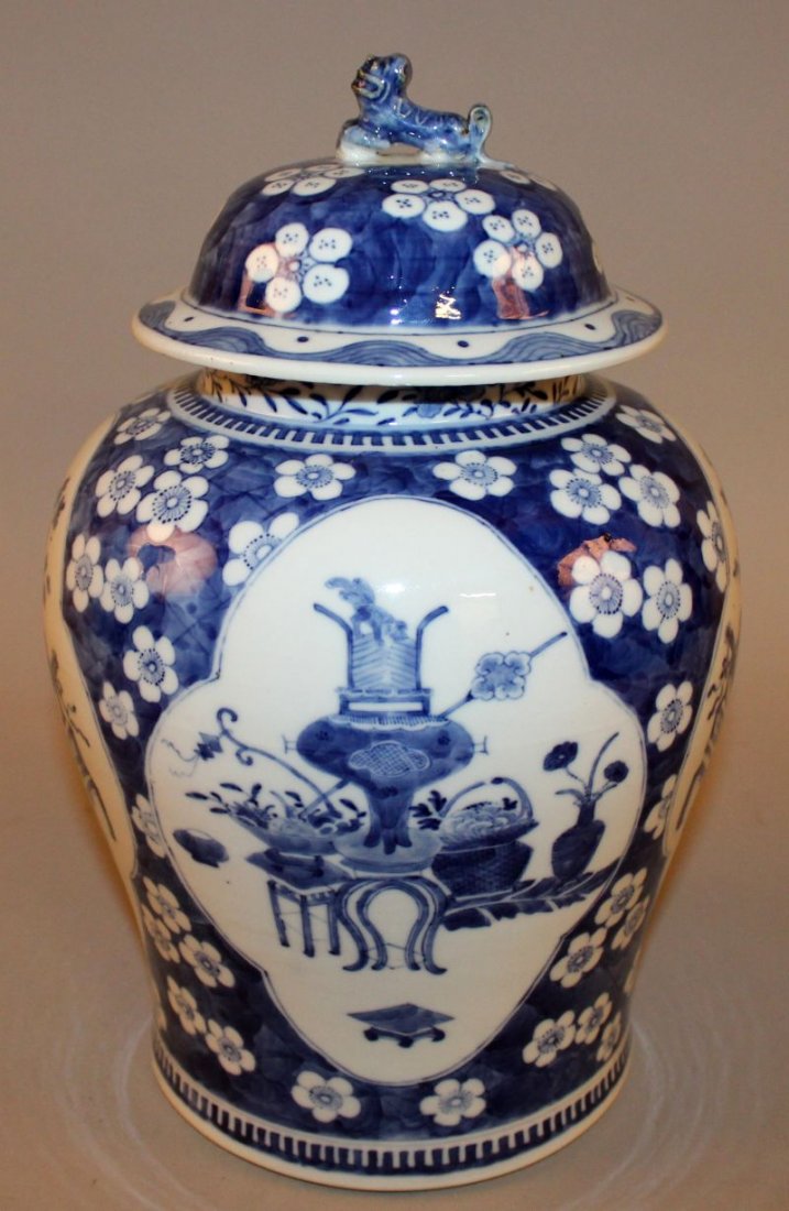 A 19TH CENTURY CHINESE BLUE & WHITE PORCELAIN JAR &: A 19TH CENTURY CHINESE BLUE & WHITE PORCELAIN JAR & COVER, the sides painted with quatrefoil panels of precious objects reserved on a ground of prunus blossom and crackled ice, the base with a four-ch