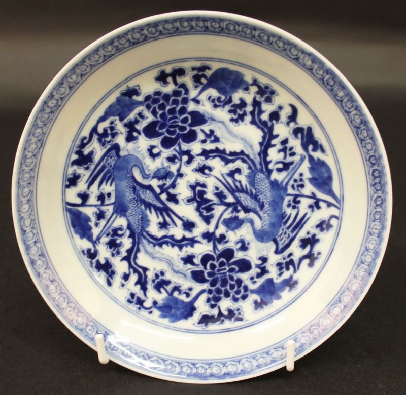 A CHINESE BLUE & WHITE PORCELAIN DISH, the interior: A CHINESE BLUE & WHITE PORCELAIN DISH, the interior painted with twin phoenix and peony, the base with a six-character Kangxi mark, 6.6in diameter. £50-80
